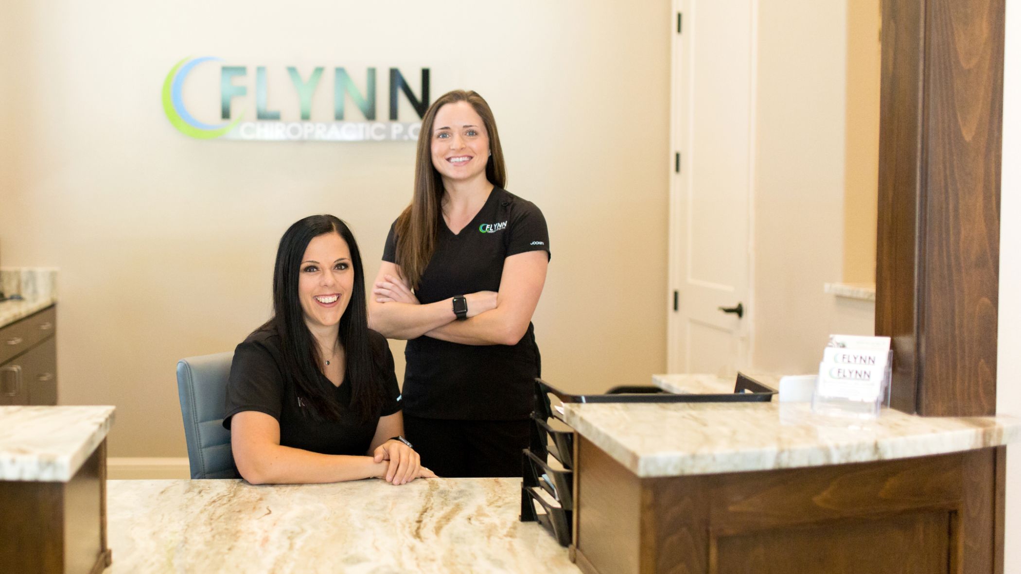 Two smiling women at front desk